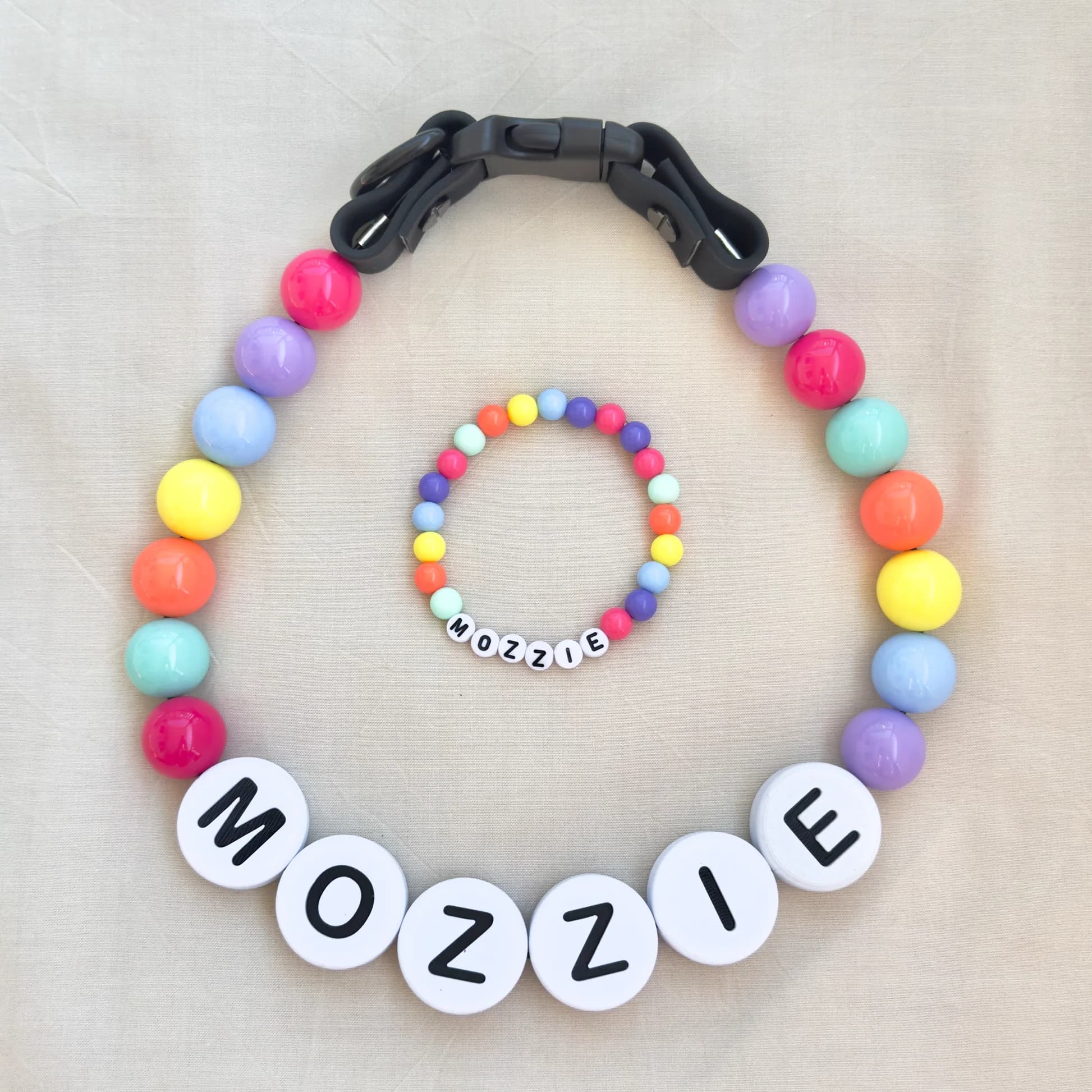 A rainbow beaded collar spelling MOZZIE with a matching bracelet
